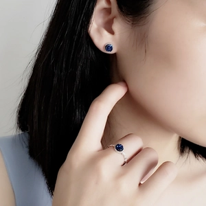 Elegant S925 sterling silver jewelry set featuring blue gemstone studs and ring on a model