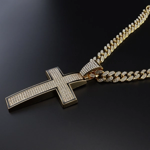 Detailed close-up of a golden Cuban link chain with a black border rhinestone cross pendant