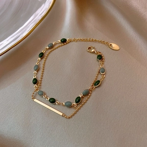 Bracelet double rang plaqué or avec pierres vertes et grises sur soie champagne