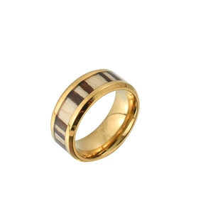 Detail showing gold metal ring featuring inlaid dark wood grain texture and polished edges