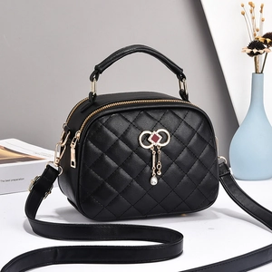 Elegant black quilted crossbody bag with golden hardware and tassel bow accessory