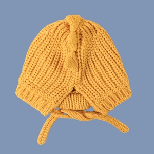 Detailed knit texture of ginger yellow dinosaur baby hat with 3D scales and chin straps