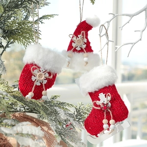 Three-piece red knit Christmas ornaments including glove, hat, and skate sock hanging on tree