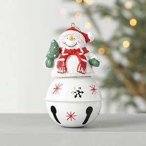 Christmas snowman bell ornament with white metal stars and red hat on a festive background