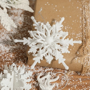 Sparkling white snowflake ornaments for Christmas tree decor on rustic gift box background