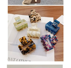 Flat lay of small leopard print acetate claw clips in marble and amber resin colors