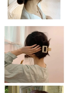 Close-up of golden necklace and marble pattern leopard hair claw clip in a lifestyle setting