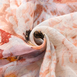 Close-up of butterfly scarf fabric in orange-pink with woven golden silk threads