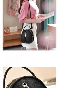 Detail of black pebbled leather mini backpack with gold rose zippers and earphone port
