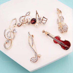 5-piece gold musical note brooch set with rhinestones and pearls on a light blue background