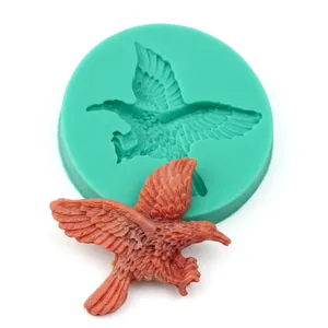 Detail of green silicone mold and eagle-shaped handicraft with intricate feather textures