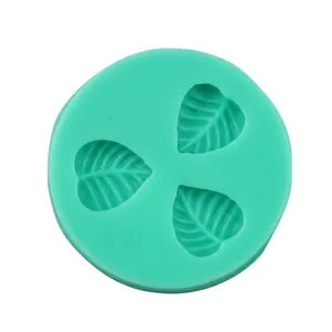 Detail of mint green silicone mold with three leaf-shaped cavities for fondant and baking