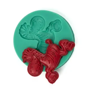 Close-up of green silicone dinosaur mold and red cookie cutter for DIY baking crafts