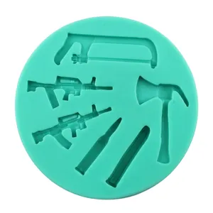 Green silicone mold featuring miniature rifle, saw, axe and dagger shapes for DIY fondant