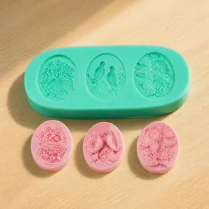 Detail of mint green silicone mold with embossed bird and floral patterns for fondant