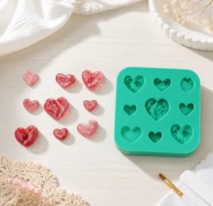 Detailed view of green silicone mold with heart shapes and pink resin craft output