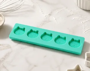 Close-up of flexible green silicone baking mold featuring five cat-shaped cavities