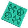 Macro view of green square silicone mold with skull and crossbones shaped cavities