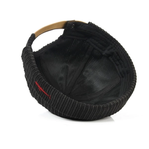 Close-up of black corduroy docker hat with red fish embroidery and leather strap