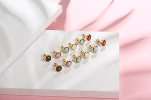 Detailed view of vintage cracked pattern stud earrings in multiple colors on a stand