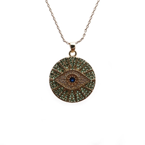 Gold evil eye necklace with colorful green and blue cubic zirconia on white background