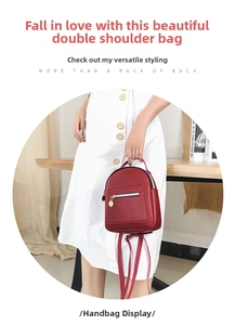 Detail of red leather mini backpack showing the gold zipper and front pocket