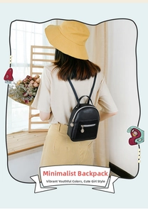 Detailed back view of a woman wearing a black mini faux leather backpack with silver zippers