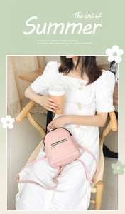 Detail of pink small crossbody backpack with gold zippers shown in a lifestyle setting