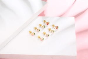 Detail of colorful strawberry enamel earrings with secure screw backs on white pedestals