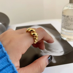 Detailed view of a gold-toned twist rope ring worn on finger with a vintage aesthetic