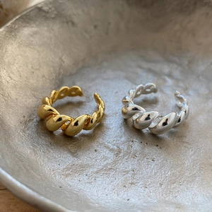 Detailed view of gold and silver twisted rope rings with a polished minimalist finish