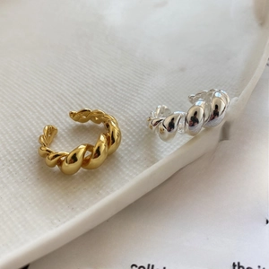Detailed close-up of S925 sterling silver twisted ring on white textured ceramic