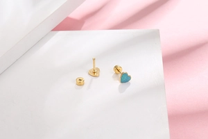 Detailed close-up of heart-shaped earrings with blue glitter and gold-plated screw backs