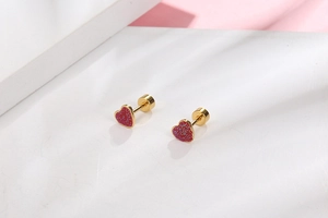 Macro view of gold-plated stainless steel red heart stud earrings with threaded flat backs