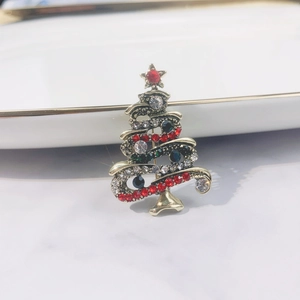 Close-up of golden Christmas tree brooch with vibrant red and green rhinestones