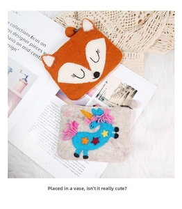 Detail showing handmade felt coin purses with cute fox and unicorn designs in wool texture
