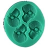 Detail shot of a green silicone mold featuring four skull shapes for DIY cake baking