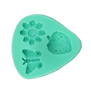 Detail of mint green silicone mold with flower, butterfly, and strawberry patterns