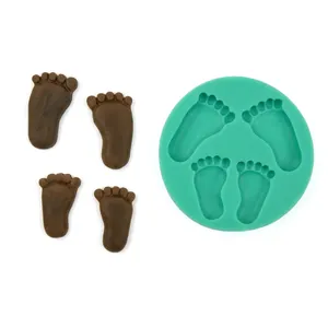 Close-up of green silicone mold and chocolate baby feet fondant shapes for DIY baking