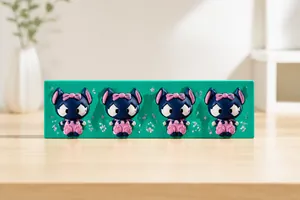 Detailed view of four black cartoon doll silicone molds with pink bow and skirt designs