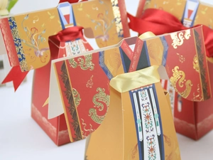 Gros plan de boîtes de mariage chinoises en forme de Hanfu avec rubans de soie