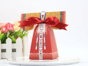 Détail de la boîte à bonbons de mariage style Hanfu rouge avec motifs dorés et ruban