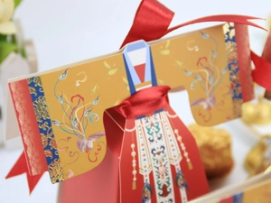 Détail de la boîte à bonbons de mariage chinois au design Hanfu avec ruban rouge