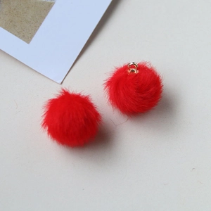 Close-up of a red plush pom-pom pendant with a golden metal loop for DIY jewelry making