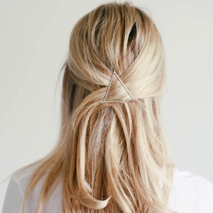 Minimalist silver triangle metal hair clip worn on blonde hair for a stylish look