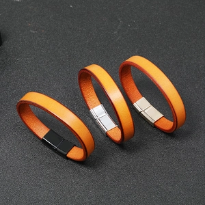 Close-up of orange leather bracelet with magnetic metal clasp on textured background