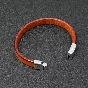 Macro shot of brown leather strap and silver magnetic clasp with metallic texture