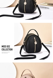 Detail of black pebbled leather crossbody bag with triple gold rose zipper pulls