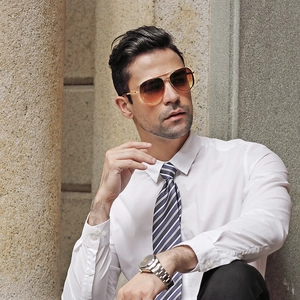 Detail of classic aviator sunglasses with gold metal frame and gradient brown lenses