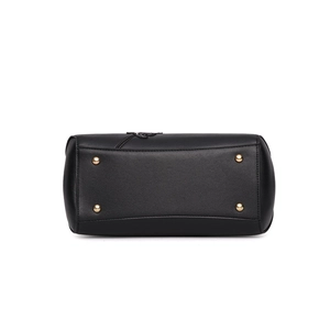 Bottom view of black leather handbag featuring four gold protective metal rivets